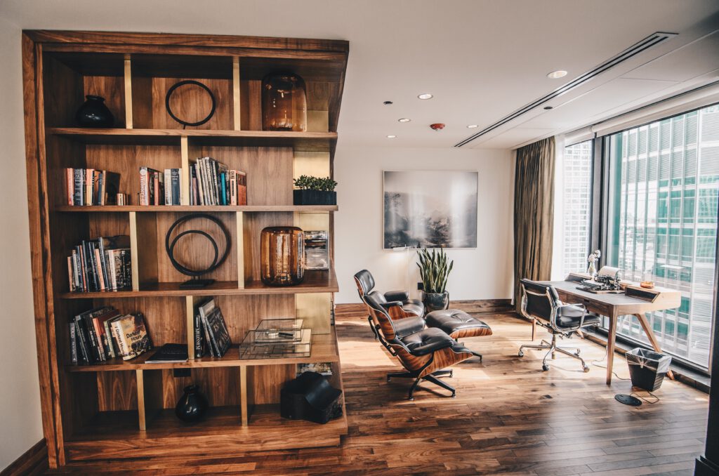 Bücherregal aus Holz in einem Homeoffice mit Schreibtisch und Stühlen.